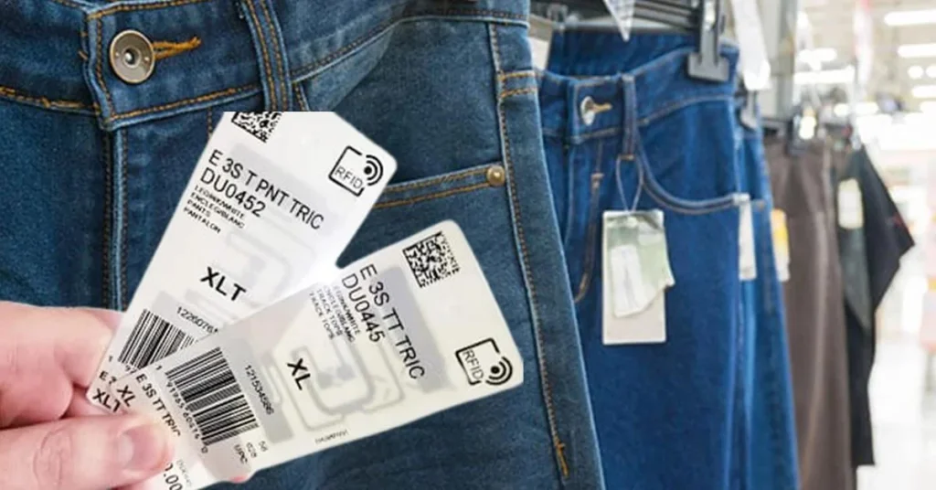 RFID apparel tags attached to denim jeans in a retail store, enabling inventory tracking, stock management, and faster checkout using RFID technology.