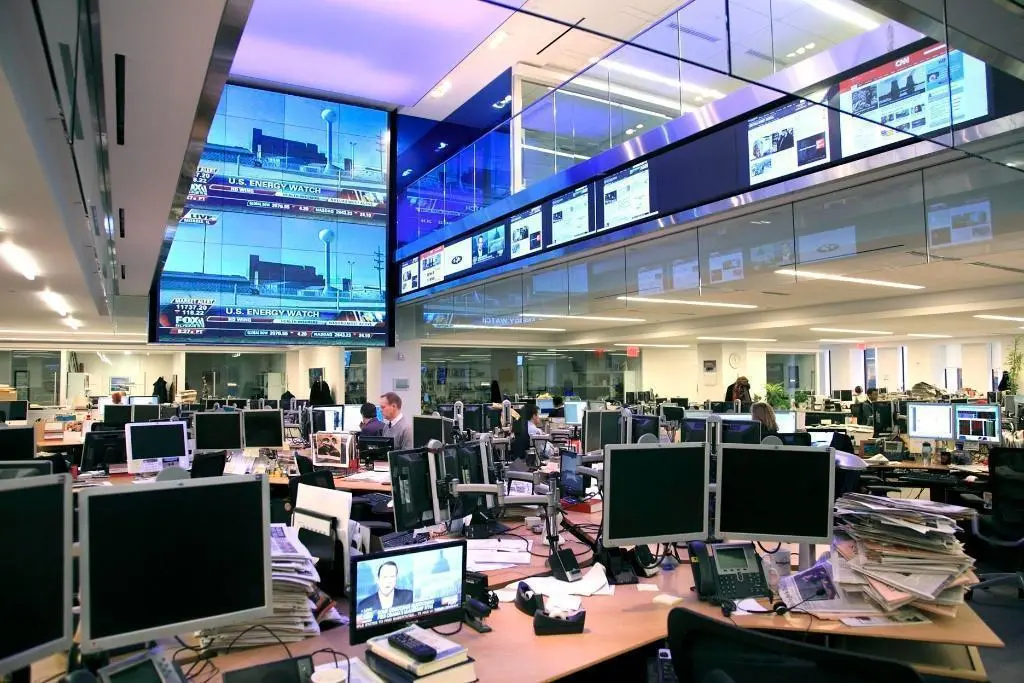 Business news headlines and financial market updates displayed on digital screens.